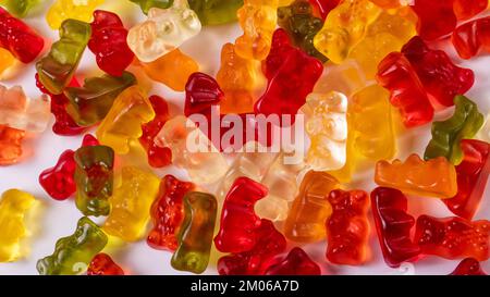 Pile de bonbons à l'ours colorés et délicieux sur fond blanc. Banque D'Images