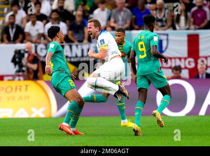 Le Harry Kane (au centre) d'Angleterre est défié par Abdou Diallo (à gauche) du Sénégal lors du match de la coupe du monde de la FIFA de seize points au stade Al-Bayt à Al Khor, au Qatar. Date de la photo: Dimanche 4 décembre 2022. Banque D'Images