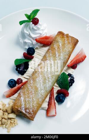 strudel traditionnel aux pommes avec crème fouettée et baies fraîches Banque D'Images