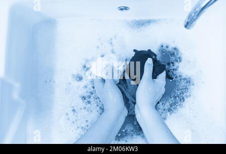 Blanchisserie lavabo avec différents vêtements clored lavage des mains Banque D'Images