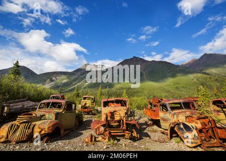 Une gamme de camions rouillés abandonnés après la guerre qui rouillent dans le désert pendant l'été dans le nord du Canada Banque D'Images