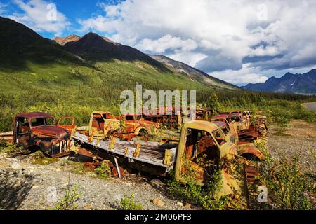 Une gamme de camions rouillés abandonnés après la guerre qui rouillent dans le désert pendant l'été dans le nord du Canada Banque D'Images