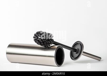 Brosse de toilette noire isolée sur blanc. Gros plan d'une brosse de nettoyage de toilettes avec éléments métalliques à insérer dans un projet ou un design. Brosse métallique pour Banque D'Images