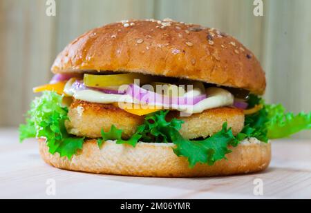 Savoureux hamburger grillé avec poulet, concombre, fromage et laitue Banque D'Images