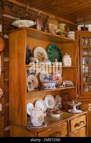 Buffet antique avec chinaware dans la cuisine à l'intérieur de la vieille maison en rondins de style chalet Canadiana reconstruite dans les années 1800. Banque D'Images