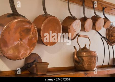 bouilloire en cuivre et casseroles au-dessus du manteau du foyer à l'intérieur de la vieille maison en rondins de style chalet Canadiana reconstruite dans les années 1800. Banque D'Images