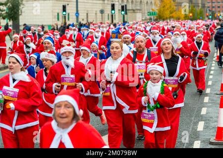 Liverpool, Royaume-Uni. 04th décembre 2022. Les coureurs font la course pendant la course annuelle de Liverpool Santa Dash. Des milliers de coureurs emportent dans les rues de Liverpool vêtus de père Noël en costume rouge et bleu de Santa lors du BTR Liverpool Santa Dash 2022, une collecte de fonds en 5k pour des organismes de bienfaisance dont l'hôpital pour enfants Alder Hey. Crédit : SOPA Images Limited/Alamy Live News Banque D'Images