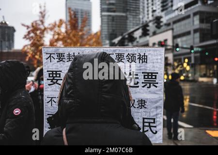 Bellevue, États-Unis. 04th décembre 2022. Un manifestant tient un écriteau pendant la démonstration. Les manifestants ont organisé un rassemblement sous la forte pluie en solidarité avec le peuple Urumqi à Bellevue, à Seattle. En Chine, le « livre blanc » était connu sous le nom de « Révolution de A4 ». Dans le parc du centre-ville de Bellevue, une vingtaine de manifestants se sont rassemblés pour manifester contre la politique « zéro covid » de la Chine et prier pour les victimes du tragique incendie à Urumqi. Crédit : SOPA Images Limited/Alamy Live News Banque D'Images