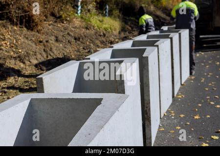 Afin de drainer la route de reconstruction, des drains préfabriqués en béton en forme de U ont été installés le long de la route Banque D'Images