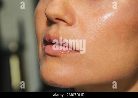 Maquilleuse applique du rouge à lèvres rose brillant. Belle visage de femme. Main d'un maître de maquillage peinture lèvres d'un modèle de beauté jeune fille. Maquillage dans le progr Banque D'Images