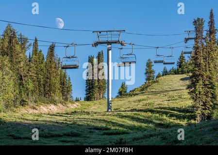 Une demi-lune lumineuse sur un télésiège Sunshine Village en été Banque D'Images