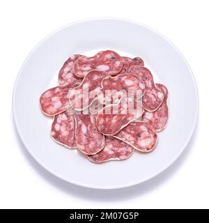 Tranches de saucisse de salami séchée fine Fuet espagnole sur plaque de céramique blanche isolée sur fond blanc Banque D'Images