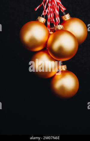 boules de noël dorées dans la main de la femme isolées sur fond noir. Carte du nouvel an, publicité, photo pour histoire, félicitations Banque D'Images