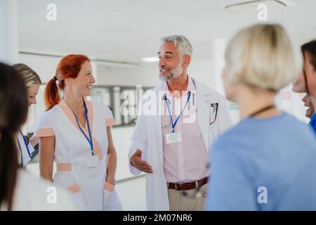 Équipe de médecins discutant de quelque chose dans un couloir hospitalier. Banque D'Images