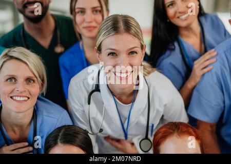 Vue en grand angle des médecins, infirmières et autres membres du personnel médical heureux de l'hôpital. Banque D'Images
