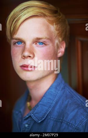 Perçage des yeux bleus. Jeune homme blond attentionné et charmant avec des yeux très bleus. Banque D'Images