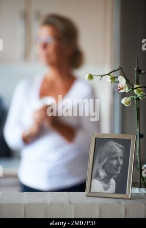 Comment le temps passe... Une femme âgée derrière une photo d'elle-même comme une belle jeune fille. Banque D'Images