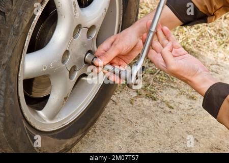 Processus de service. Un homme tient un pneu dans le garage. Remplacement des pneus hiver et été. Concept de remplacement saisonnier des pneus Banque D'Images