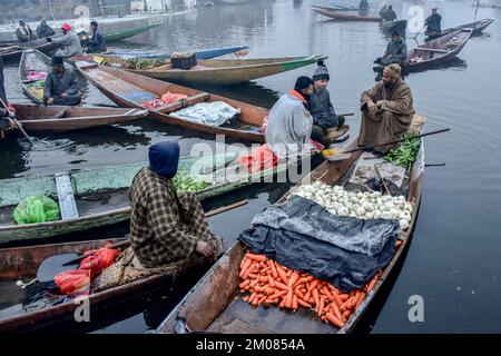 Les vendeurs de légumes se rassemblent sur un marché flottant à l'intérieur du lac Dal pendant une matinée hivernale froide à Srinagar. Dal Lake est célèbre pour son marché de légumes flottant qui fournit des variétés de légumes toute l'année à de nombreuses villes de la vallée du Cachemire. Ce marché de légumes flottant comprend de nombreux jardins flottants ainsi que des variétés locales de légumes biologiques. C'est l'un des marchés flottants les plus célèbres au monde. Le marché aux légumes ouvre à 4 heures le matin même avant que le soleil ne se lève et se ferme dans les deux heures suivantes. Banque D'Images