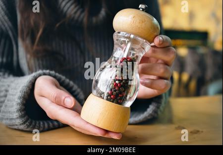 Gros plan, bouteille de poivre dans des récipients avec moulin à café. Banque D'Images