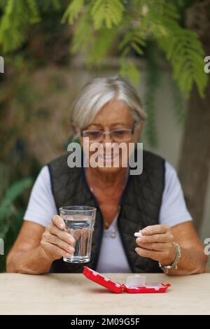 Portrait de tête de tir la femme heureuse tient le verre de pilule de l'eau, prend la médecine quotidienne vitamine D, les suppléments d'oméga 3, la peau cheveux de renforcement des ongles et de la beauté Banque D'Images