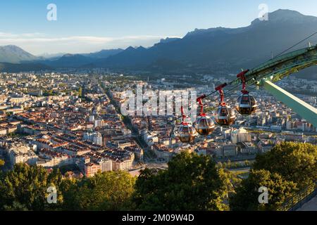 Horizon de la ville de Grenoble au coucher du soleil avec les téléphériques du fort de la Bastille. Été en Isère, région Rhône-Alpes, France Banque D'Images