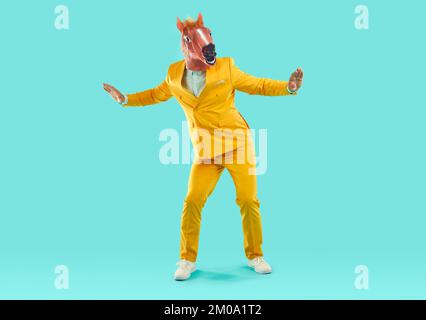 Homme portant un masque de cheval dansant en studio Banque D'Images
