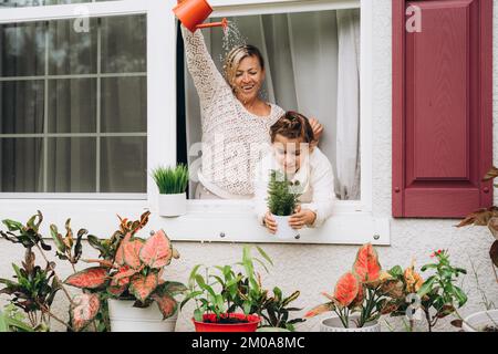 Fille avec maman arrosoir des plantes d'un arrosoir Banque D'Images