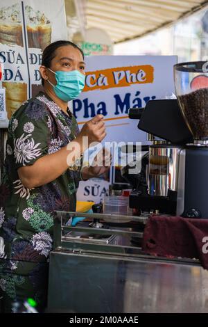 Ho Chi Minh ville, Vietnam - 10 novembre 2022: Une femme vietnamienne fait du café traditionnel dans un petit magasin sur le trottoir dans le district 1 de Sai Banque D'Images