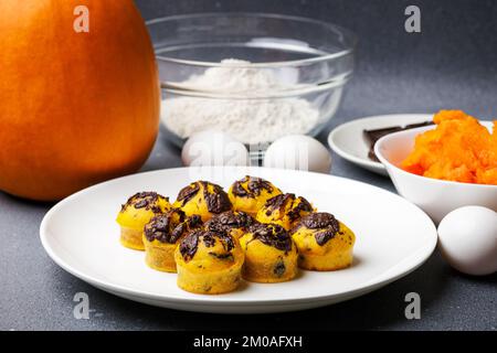 De jolis petits muffins de citrouille servis à la table avec des ingrédients. Mouffin boulangerie fond de cuisine maison Banque D'Images