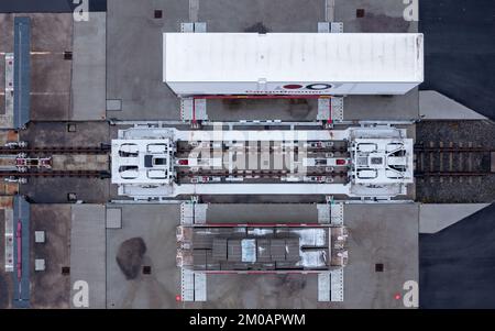 05 décembre 2022, Saxe, Leipzig: Une semi-remorque est chargée sur un wagon dans une station de fret en utilisant une nouvelle technique de chargement. La société CargoBeamer basée à Leipzig veut rendre le transport de marchandises en Europe plus efficace et plus respectueux de l'environnement. Dans le nouveau terminal, les remorques de camions peuvent être déplacées latéralement sur le wagon à l'aide d'un bac de chargement. Cela permet de contourner le problème suivant : presque toutes les remorques ne peuvent pas être levées par grue, ce qui rend le chargement par rail coûteux et inutile. Le premier terminal de la société est en exploitation à Calais, dans le nord de la France Banque D'Images