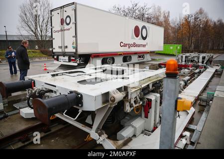 05 décembre 2022, Saxe, Leipzig: Burkhard Jung (SPD), Lord Mayor of Leipzig, regarde comme une semi-remorque avec une nouvelle technologie de chargement est chargée sur un wagon dans une station de fret. La société CargoBeamer, basée à Leipzig, souhaite l'utiliser pour rendre le transport de marchandises en Europe plus efficace et plus respectueux de l'environnement. Dans le nouveau terminal, les remorques de camions peuvent être déplacées latéralement sur le wagon à l'aide d'un bac de chargement. Cela permet de contourner le problème suivant : presque toutes les remorques ne peuvent pas être levées par grue, ce qui rend le chargement par rail coûteux et inutile. La maquette Banque D'Images