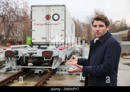 05 décembre 2022, Saxe, Leipzig: Nicolas Albrecht, PDG CargoBeamer, explique comment une semi-remorque est chargée sur un wagon dans une station de fret en utilisant une nouvelle technique de chargement. La société CargoBeamer, basée à Leipzig, vise à rendre le transport de marchandises en Europe plus efficace et plus respectueux de l'environnement. Dans le nouveau terminal, les remorques de camions peuvent être déplacées latéralement sur le wagon à l'aide d'un bac de chargement. Cela permet de contourner le problème suivant : presque toutes les remorques ne peuvent pas être levées par grue, ce qui rend le chargement par rail coûteux et inutile. Le premier termin de l'entreprise Banque D'Images