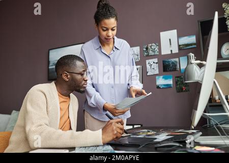 Équipe créative discutant des photos à télécharger sur le Web Banque D'Images