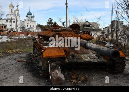 Un char russe détruit se tient près de la route devant un temple orthodoxe dans la ville libérée de Sviatohirsk. La Russie perd de 50 à 100 soldats chaque jour dans la bataille de Bakhmut, au milieu de ses tentatives désespérées de capturer la ville dans l'oblast de Donetsk, à l'est, a déclaré un porte-parole militaire le 4 décembre. S'exprimant à la télévision, le porte-parole du Commandement militaire de l'est, Serhiy Cherevaty, a déclaré qu'environ autant de soldats russes sont blessés en action près de Bakhmut chaque jour. Pendant des mois, la Russie a massé des troupes et du matériel pour entourer et capturer Bakhmut dans une campagne brutale qui a été menée par l'État russe Banque D'Images