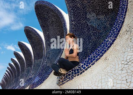 Femme méditant à la Cité des Arts et des Sciences, Valence, Espagne. Assis à pieds croisés au soleil Banque D'Images