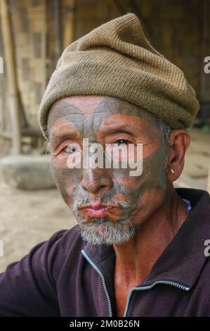 Mon district, Nagaland, Inde - 11 18 2010 : gros plan portrait d'un chasseur de tête de tribu naga d'âge moyen avec chapeau de tatouage traditionnel Banque D'Images