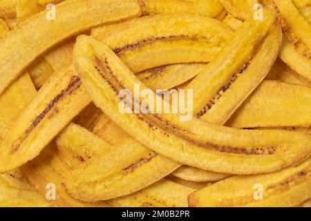 Les croustilles de banane fraîches se rapprochent du plein cadre comme arrière-plan Banque D'Images