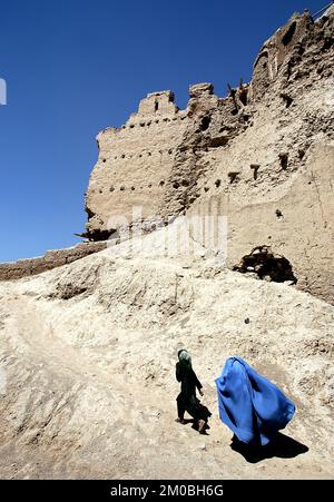 Une fille et une femme se promènent sur le mur de la citadelle de Ghazni à Ghazni, en Afghanistan. La femme porte une burqa bleue (burka), traditionnelle dans le centre de l'Afghanistan Banque D'Images