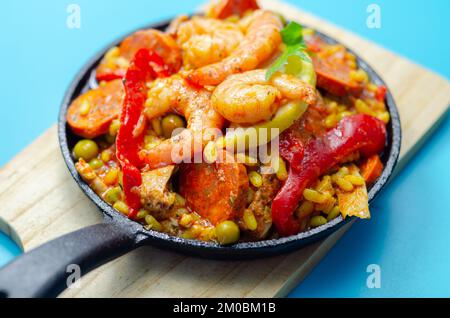 Paella délicieuse, riz risotto cuit avec cuisse de poulet, crevettes royales, tomates et chorizo, repas espagnol traditionnel Banque D'Images