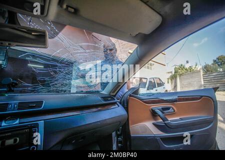 Naplouse, Palestine. 05th décembre 2022. Le palestinien Mohammed Odeh, 54 ans, inspecte sa voiture détruite après que les colons lui ont lancé des pierres près de Hawara, au sud de Naplouse, en Cisjordanie. Odeh dit que quatre colons juifs ont jeté des pierres sur sa voiture et l'ont battu, lui et sa femme, les blessant. Crédit : SOPA Images Limited/Alamy Live News Banque D'Images