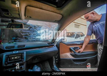 Naplouse, Palestine. 05th décembre 2022. Le palestinien Mohammed Odeh, 54 ans, inspecte sa voiture détruite après que les colons lui ont lancé des pierres près de Hawara, au sud de Naplouse, en Cisjordanie. Odeh dit que quatre colons juifs ont jeté des pierres sur sa voiture et l'ont battu, lui et sa femme, les blessant. Crédit : SOPA Images Limited/Alamy Live News Banque D'Images