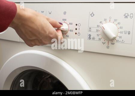 une personne choisit un mode de lavage à l'aide d'un interrupteur. mode de lavage. Banque D'Images