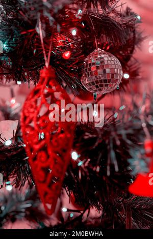 Décoration de Noël rouge oblongue accrochée à un arbre de Noël Banque D'Images