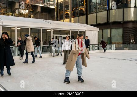 Une femme vérifie son smartphone en patinant sur la patinoire du développement de Manhattan West à New York mardi, 29 novembre 2022. (© Richard B. Levine) Banque D'Images