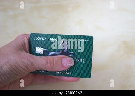 Carte bancaire Lloyds à portée de main sur fond clair. Banque D'Images