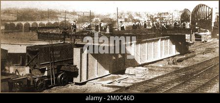 Années 1930 - (à gauche) une poutre transportée pendant la construction du pont ferroviaire de Saltash G.W.R. à Saltash, Royaume-Uni, avec des travailleurs debout au-dessus. Banque D'Images