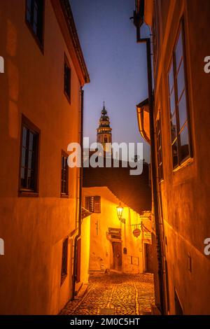 Une vue nocturne rêveuse à travers la ville historique emblématique de Cesky Krumlov avec un ciel magique et des lumières des rues en début de soirée. Banque D'Images