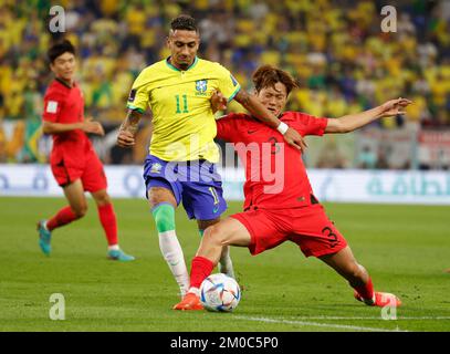 Doha, Qatar. 5th décembre 2022. Kim Jin-su (R) de Corée du Sud rivalise avec Raphinha du Brésil lors de leur match de la série 16 à la coupe du monde de la FIFA 2022 au stade Ras Abu Aboud (974) à Doha, Qatar, le 5 décembre 2022. Crédit: Wang Lili/Xinhua/Alay Live News Banque D'Images