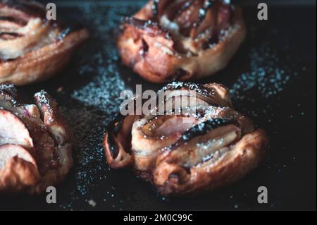 Roses de pomme en pâte feuilletée sur la plaque de cuisson Banque D'Images